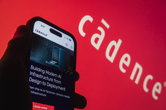 Raleigh, North Carolina - August 3rd, 2026: Silhouette of a hand holding a smartphone showing the Cadence Design Systems (CDNS) website homepage with the brand logo in the background.