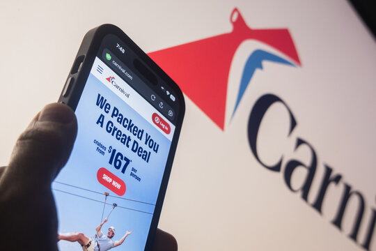 Raleigh, North Carolina - August 3rd, 2026: Silhouette of a hand holding a smartphone showing the Carnival Corporation (CCL) website homepage with the brand logo in the blue background.