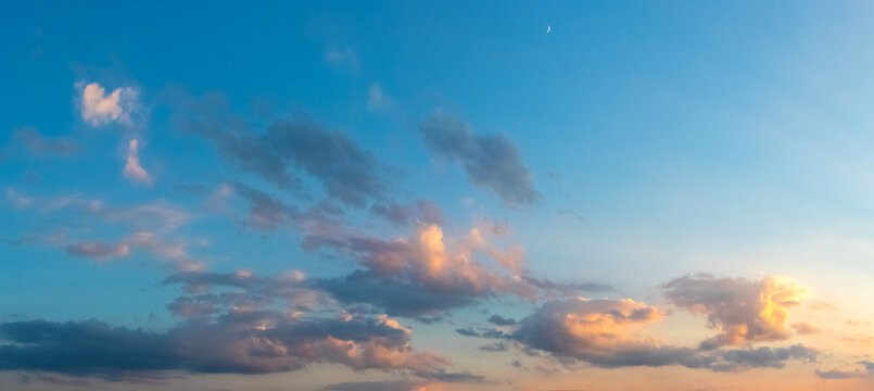 Panoramic evening sky with pink clouds and crescent moon sunset