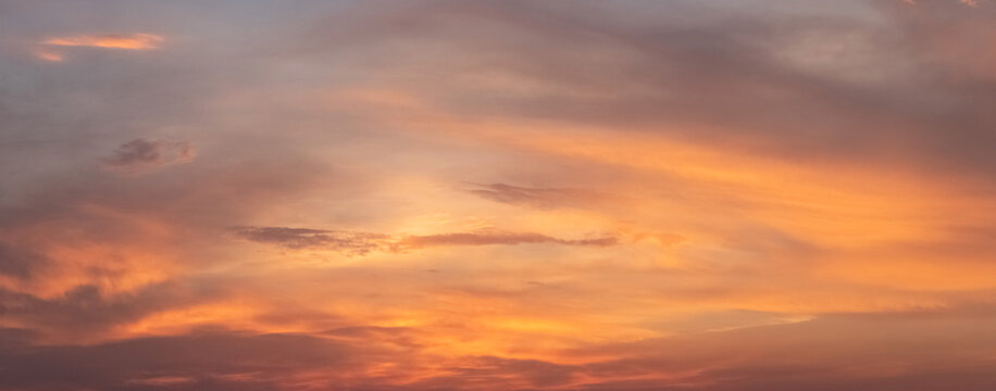 Bright orange sky with clouds during evening sunset