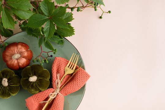 Autumn Table Setting With Decorative Pumpkins Orange Napkin And Gold Cutlery On Green Plate
