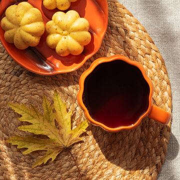 Pumpkin Shaped Muffins and Hot Beverage in Autumn Themed Setting