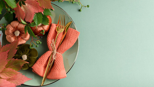 Autumnal Thanksgiving Table Setting With Decorative Pumpkins And Fall Leaves