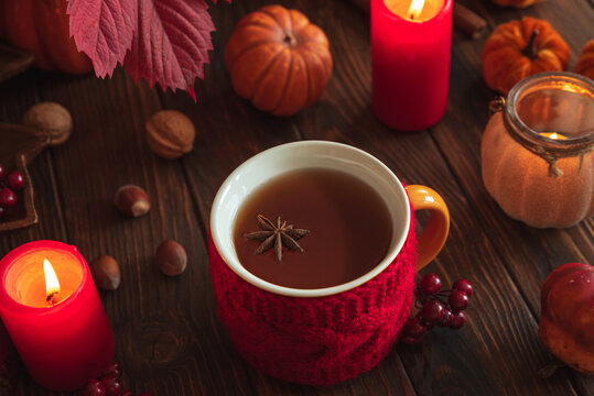 Cozy Autumn Evening Tea Scene with Pumpkins Candles and Nuts on Wooden Table