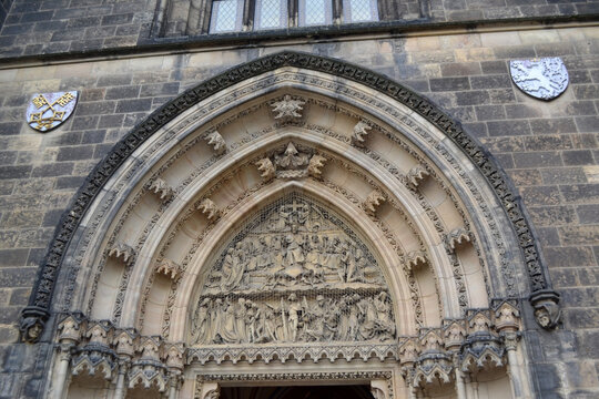 Gothic carved church portal arch with sculpted tympanum and decorative reliefs for historic architecture background and restoration. Basilica of St Peter and St Paul, Prague.