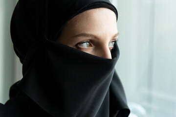 Naklejka premium Contemplative gaze through black veil.