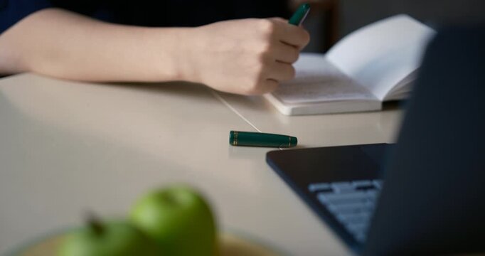 Cinematic close-up of a person writing notes with a fountain pen beside a laptop in a modern workspace, representing productivity, planning, education, creativity, and professional office lifestyle.