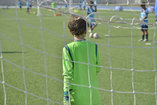 giovane portiere durante un allenamento di calcio davanti alla rete della porta