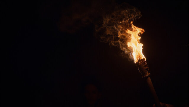 burning wooden torch in the dark night with smoke left copyspace