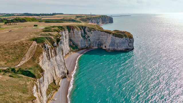 Top down aerial perspective of a coastal cliff formation meeting turquoise water