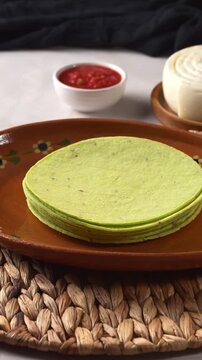High angle view of green nopal tortillas fresh quesillo cheese and red salsa on table