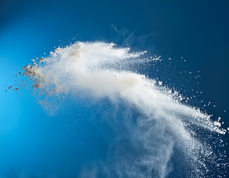high speed photography of white flour exploding in motion against a light blue background capturing a clean and dynamic composition with natural shadows and minimalist textures perfect for studio