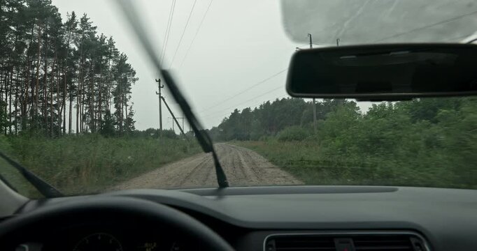 Car wipers sweeping rain from windshield while driving on dirt road with audio included