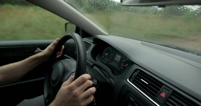 Close up of male hands holding steering wheel inside car with audio included