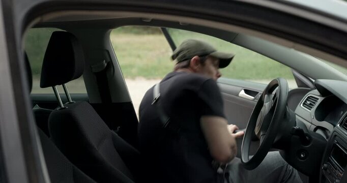 Man getting into car and starting engine for forest road trip with audio included