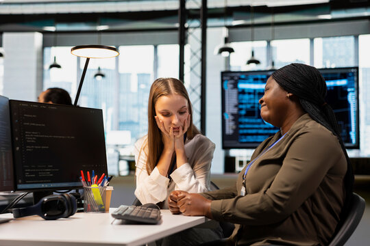 Worried employee shares concerns with an empathetic team leader at a desk as the colleague offers encouragement, comfort and emotional support during a difficult workplace conversation in the office.