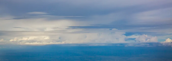 Cumulus clouds floating, in open sky, with clouds, from a aerial view from above the clouds perspective, with white, blue accents, and serene expansive mood, with nearby objects. © Evgeniia Biriukova