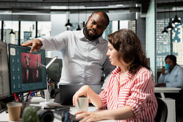 Diverse photographers use an AI virtual assistant and text-to-image software on a monitor to...