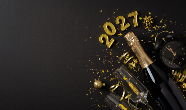 Happy New Year 2027 celebration with champagne, glasses, confetti and countdown clock on black