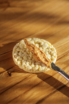 Spreading Peanut Butter On Crunchy Rice Cake Snack