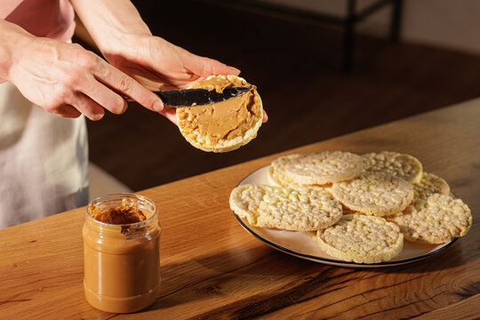 Spreading Peanut Butter on Crisp Rice Cakes for Healthy Snack