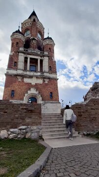 Gardos Tower, also known as Kula Gardos, a historic landmark in the Zemun district of Belgrade, Serbia. A visitor walks up the steps toward the tower entrance. Vertical Video