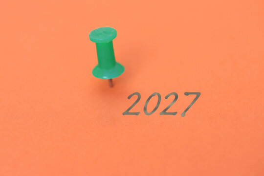 Eine Heftzwecke und ein Blatt Papier mit der Jahreszahl 2027
