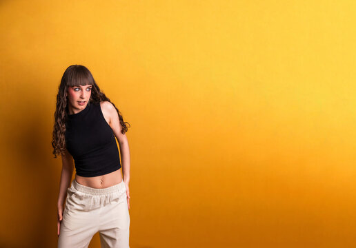 Female dancer performing urban style move against yellow background
