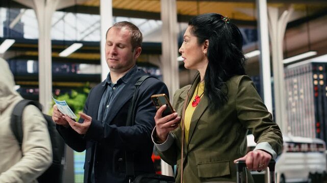 Business travelers compare a printed bus ticket with smartphone information, checking boarding pass details and a phone navigation app together.