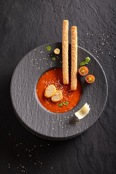 Exquisite and tasty tomato soup with high-end presentation on plate.