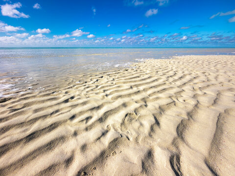 Crystal clear shallow lagoon with pristine white sand, gentle wave patterns and sunlight over clear water at Heron Island, Queensland, Australia.