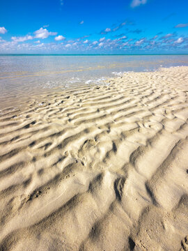 Crystal clear shallow lagoon with pristine white sand, gentle wave patterns and sunlight over clear water at Heron Island, Queensland, Australia.