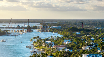 Aerial view of Jupiter showcasing the winding waterway, red lighthouse, and coastal buildings under clouds. December 29, 2022.  © JHorsey