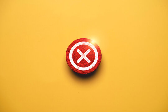 Red cross mark icon on yellow background representing error, cancel, rejection, failure, incorrect choice, prohibited action, warning, and negative decision with copy space for design.