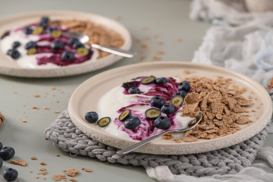 Mini cheesecakes with blueberry compote and cereal on plates