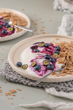 Mini cheesecakes with blueberry compote and cereal on plates