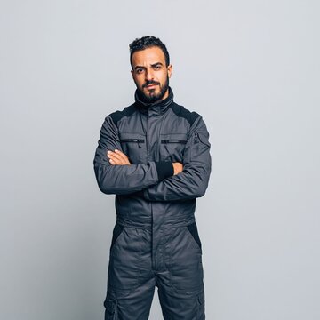 Male workers in uniforms with natural smiles, emphasizing reliability, confidence, and professional skill in the studio set up light and background..