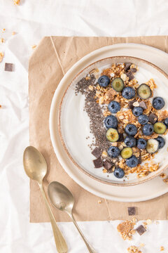 Healthy yogurt bowl with fresh blueberries, granola, and chia seeds in a rustic ceramic dish for a nutritious, delicious morning meal