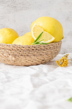Fresh yellow lemons with rosemary sprigs in basket