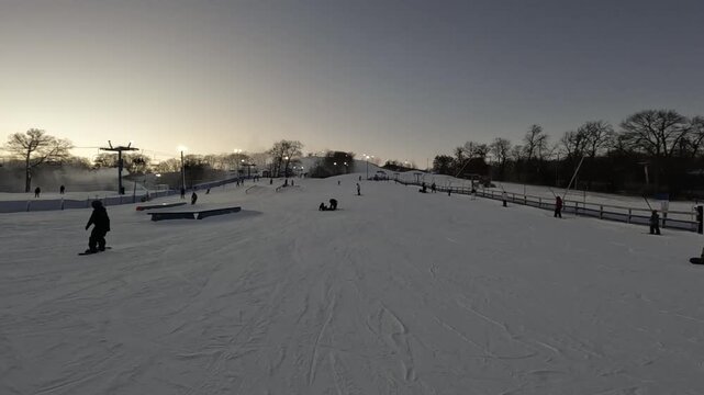 Snowboarders and skiers enjoying a sunny winter day at a snow park in Minnesota
Wide action shot of people enjoying recreational skiing and snowboarding practice at a snowy winter park
