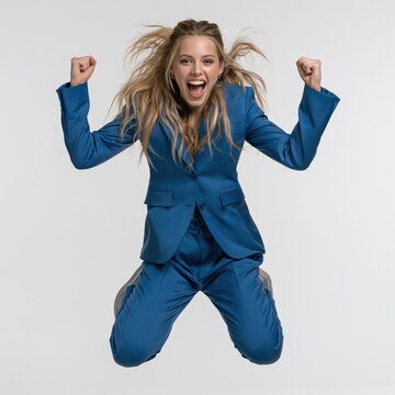 Businesswoman jumping in mid-air celebrates career success with confidence, energy, and a joyful victory pose against a clean white background.