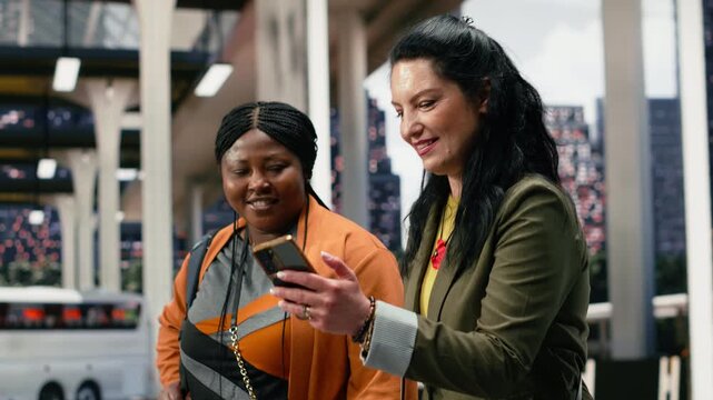 Travelers check a bus ticket online in the coach station and verify the route on a mobile phone, confirming journey details together on a smartphone inside the shuttle terminal before departure.