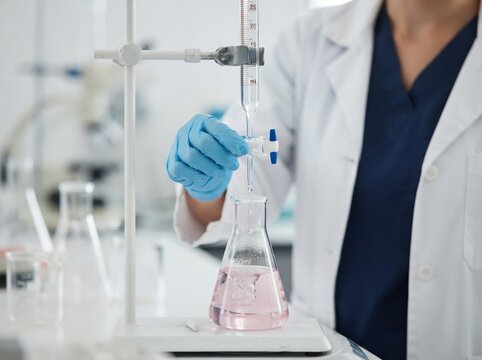 Female scientist performing chemical titration with a burette and Erlenmeyer flask in a research laboratory