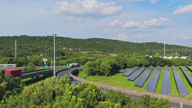 Drone rising above treetops to reveal solar panels and highway