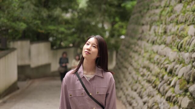東京のレトロな観光地（深大寺近くの公道）を散策する女性のフォローショット