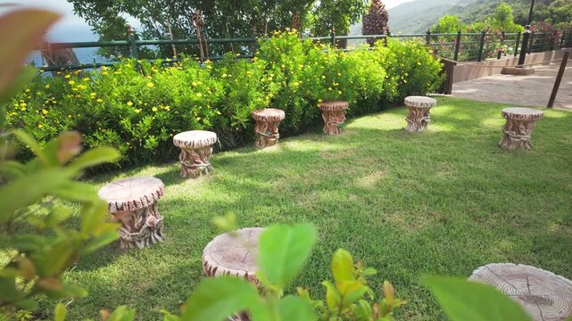 Serene Green Garden with Rustic Stools and Yellow Flowers Overlooking the Mediterranean Sea at Cap Spartel, Tangier, Morocco