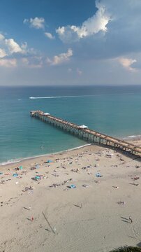 Tourists enjoying a beach day at Juno Beach Pier near Jupiter in Palm Beach County, Florida. 