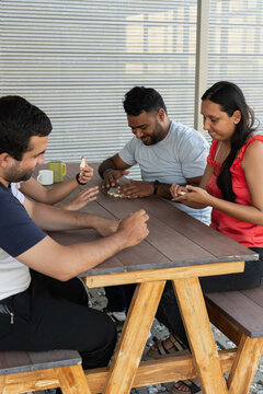 Young adults playing board game on wooden table