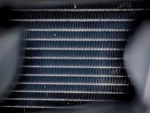 Macro texture of car radiator metal fins with industrial framing background