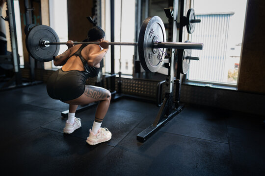 woman performing barbell back squat at full depth